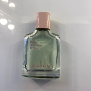 Paris 92 Champs Élysées parfym från Zara - Säljer en elegant parfym från Zara med namnet Paris 92 Champs Élysées. Flaskan är genomskinlig med en ljusrosa kork och rymmer 60 ml. Parfymen har en fräsch och sofistikerad doft, perfekt för både vardag och speciella tillfällen. Flaskan har en stilren design med rosa text på framsidan. Köp direkt eller ge prisförslag 💛