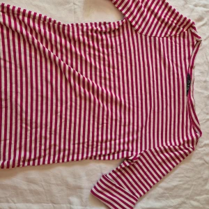 Randig tröja från Ralph Lauren - Säljer en snygg och bekväm randig tröja från Ralph Lauren. Den är vit och rosa med trekvartsärmar och ett broderat RL-märke på framsidan. Perfekt för både vardag och fest! Tröjan är i bra skick och gjord av mjukt bomullsmaterial. Passar perfekt till jeans eller kjol. 🌸