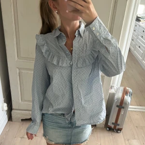 Blå skjorta  - Söt blå skjorta med både prickar och volang! 