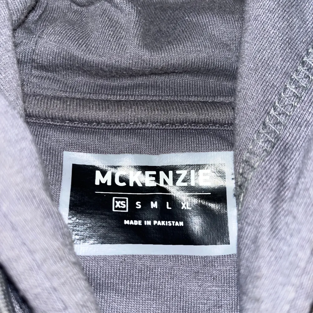 Säljer en snygg och bekväm grå hoodie från McKenzie.  Den har en stor ficka på framsidan och en svart detalj med McKenzie-loggan på bröstet. Perfekt för höst och vinter, och passar bra till både vardag och träning. Hoodien är i nyskick och väldigt mjuk och skön att ha på sig. Köp direkt eller ge prisförslag 💛. Tröjor & Koftor.