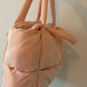 Väska  -  En fin rosa väska perfekt till gymmet till yoga pilates Den är väldigt rimlig får plats med mycket alltså och det är någon inre ficka och det har både ett litet handtag och så är det långt handtag så du kan ha en över axeln också