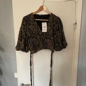 Kort topp  - Kort topp från Zara med prislapp. Puffärm och snörning i midjan
