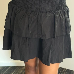 Svart kjol - Snygg svart kjol med detaljer vid midjan. Vardaglig men går att styla festligt. Snygg till skola och fest. Enkel, snygg, gullig