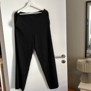 Svarta byxor - Säljer ett par stilrena svarta byxor i storlek EUR 40. Perfekta för både vardag och fest. De har en enkel design utan synliga detaljer och är gjorda i ett bekvämt material.