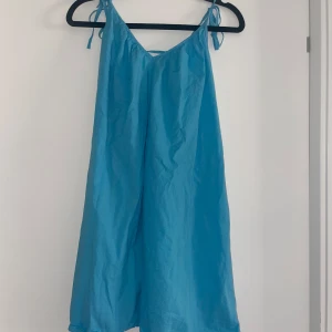Blå kort klänning  - En blå kort klänning, från H&M. Storlek S
