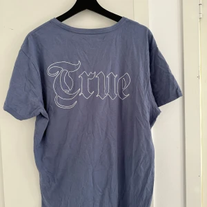 Mörk blå t-shirt  - Den mörkblå t-shirten har en enkel och tidlös design med rund hals och korta ärmar. Färgen är djup mörkblå, och materialet är mjuk bomull, vilket gör den bekväm och mångsidig för både vardagsbruk och lager-på-lager-styling.