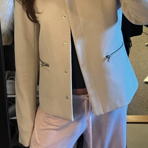 HÖSTKAPPA - Säljer en snygg jacka från Only med dragkedjor på sidorna. Jackan har en stilren design med långa ärmar och knappar framtill. Perfekt nu till hösten om man vill variera stil på kappor!🍁Defekt på sista bilden därav billigt pris (nypris 459kr) 