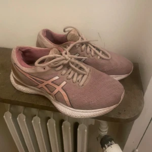 Rosa sneakers från Asics - Säljer ett par rosa sneakers från Asics. De har en snygg design med snörning och en bekväm sula. Perfekta för träning eller vardagsbruk. Lite slitna men fortfarande i bra skick.