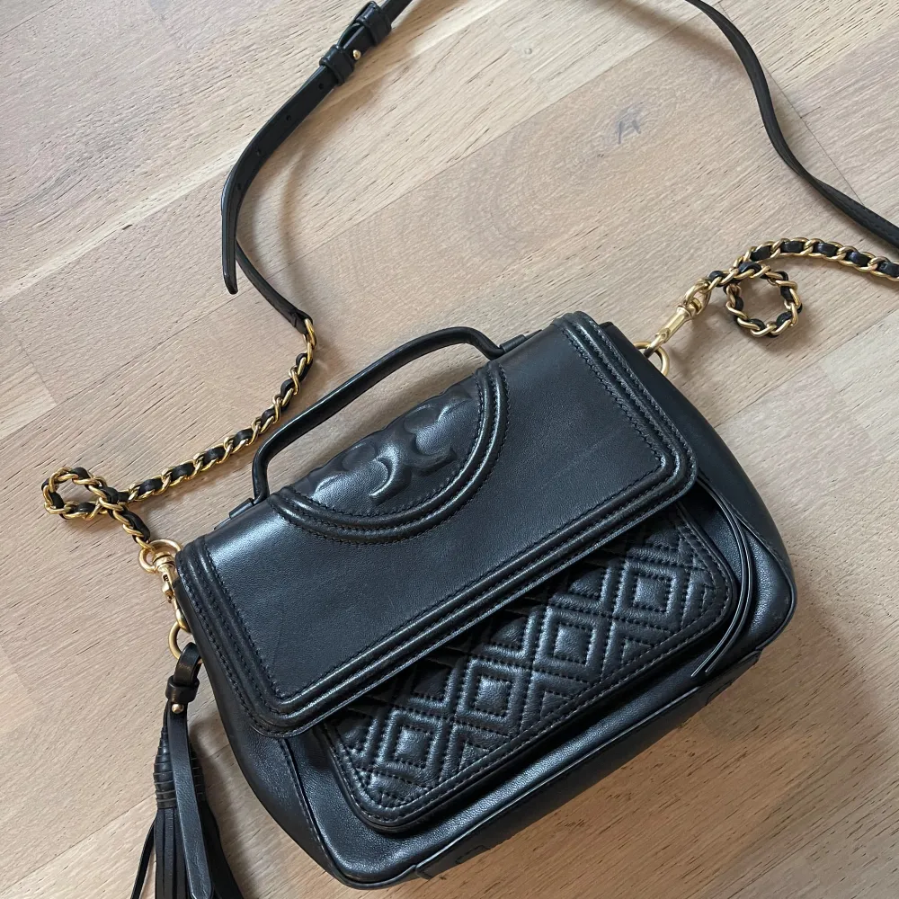 Väska från tory burch. Har en stor innerficka och en mindre utanpå. Justerbara band. Kvitto finns . Asusteet.