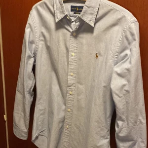 Ralph Lauren skjorta - Säljer en snygg blå skjorta från Ralph Lauren. Den är i mycket bra skick. strl S. Säljer denna då den inte passar mig i storlek. Hör gärna av dig för mer bilder. Pris kan även diskuteras.