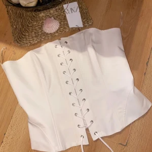 TOPP AV KORSETTMODELL I TWILL - Topp i gabardin. Rund urringning. Bara axlar. Knäppning fram med snörning och dragkedja i ryggen. Liten i storlek mest som S aldrig använd då blev för små 🌸