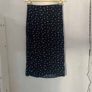 Svart kjol - Kjolen är använd några gånger men känns ny. Den har slits vid ett ben med knappar upp (se bilden) 