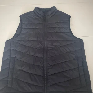 Jack & Jones väst  - Västen är storlek L, Inte använd alls, passar nu till hösten då den ger bra värme. Inga fläckar utan helt ren. Ny pris 450 kr 