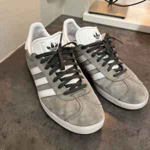 Adidas GAZELLE - Ett par grå Adidas gazelle storlek 42, okej skick men lite sönder bak på sulan 