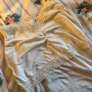 Vit linne/Topp - Säljer ett superfint vitt linne med smala axelband och vacker spetsdetalj vid halsringningen och midjan. Perfekt för sommardagar eller som ett lager under en tröja. Linnet är i helt okej skick dock lite knopprig ksk men pris diskuteras💗