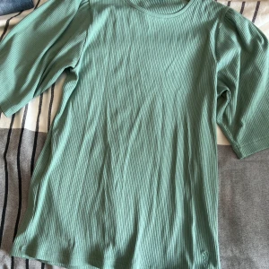 Kortärmad tröja - helt ny - Ny tröja från House of Lola i fin grön färg. Detalj med ”puff” vid ärmarna. 