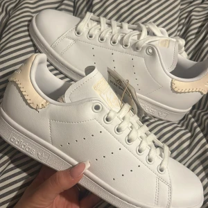 Vita Adidas Stan Smith sneakers - Säljer ett par helt oanvända Adidas Stan Smith sneakers, köpte dessa förra året, dock två storlekar för stora så de har bara legat i garderoben sen dess och har ej använts , skit snygga och i helt nytt skick (fler bilder kan man höra av sig om)