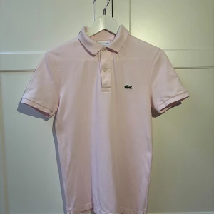 Lacoste Piké  - Säljer den här supersnygga Lacoste pikén då den tyvärr inte längre passar.  Jättefin ljusrosa färg som funkar till det mesta.❤️ Fint skick utan större defekter!! Kontakta vid frågor eller funderingar🔥❤️