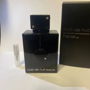 clib de nuit 2ml  - Club de Nuit Intense är en herrdoft från Armaf, känd för att likna Creed Aventus. Den kombinerar friska citrusnoter med kryddig ros och rökig mysk, vilket skapar en maskulin och långvarig doft, perfekt för kvällsbruk. Finns endast i 2ml 