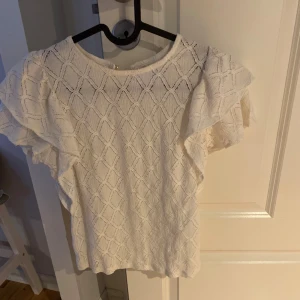 Vit spets t-shirt - Jätte söt stockholmstil topp, vit med spets och volang, bara använd ett par gånger så den är som i nyskick. Säljer denna eftersom den inte kommer till användning 