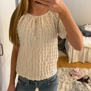 Vit blus med struktur - Säljer en superfin beige blus med en unik design. Den är perfekt för fest och är i mycket bra skick 💖💖💖 den är i barnstirlken 152 men passar xxs-s