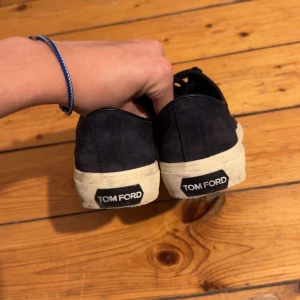 Blå mocka sneakers från Tom Ford - Säljer ett par snygga blå mocka sneakers från Tom Ford i bra skick. Köpte skorna inför sommaren och använt några gånger men fortfarande väldigt bra skick. Köpta på Farfetch.
