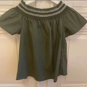 Grön off shoulder top - Grön off shoulder top med vita detaljer, använd en gång 