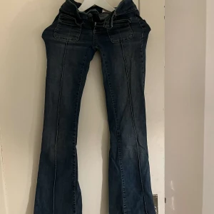 Blå bootcut jeans - Säljer ett par snygga blå bootcut jeans i bra skick från Nelly. De är slitna längst ner som man ser på andra bilde därav priset 