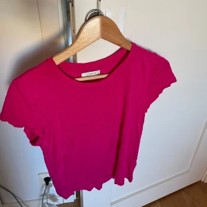 Rosa croppad topp från Lindex - Säljer en superfin rosa croppad topp från Lindex i storlek S. Den är kortärmad och perfekt för sommardagar. Toppen är i bra skick och gjord av mjukt bomullsmaterial. Passar perfekt till både jeans och kjol! 🌸