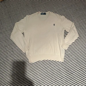 Beige Ralph Lauren tröja - Säljer denna V-ringade Ralph lauren för att jag inte har använt den så mycket på sistone. 9/10 skick och ny pris ca 2000kr men säljer för 399kr