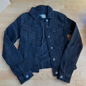 Svart jeansjacka från Bershka - Säljer en snygg svart jeansjacka från Bershka i storlek XXS. Jackan har en klassisk design med knappar framtill och två bröstfickor. Perfekt för både vår och höst! 🖤använd ett fåtal gånger