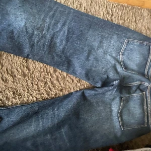 Blå jeansbyxor - Säljer ett par klassiska blå jeansbyxor i bra skick. De har en normal passform och är perfekta för vardagsbruk. Byxorna har en traditionell femficksdesign och är gjorda av slitstarkt denim. Perfekta för både höst och vår!