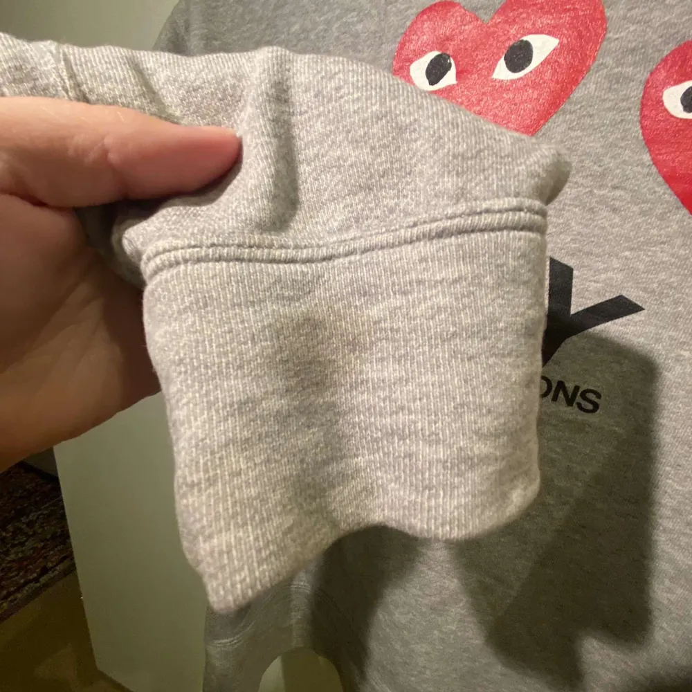 Säljer en grå hoodie från Comme des Garçons med det ikoniska röda hjärtmotivet på bröstet och flera på ryggen. Den har en dragkedja framtill och är i bra skick. Har en liten fläck längst ut på armen(se sista bilden). Tröjor & Koftor.