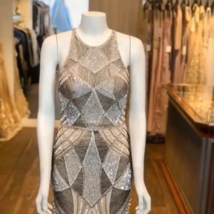 Glittrig klänning med geometriskt mönster - Säljer en fantastisk glittrig klänning med ett unikt geometriskt mönster. Klänningen har en tight passform och är ärmlös med en öppen rygg som korsas av tunna band. Perfekt för fest eller nyår! ✨