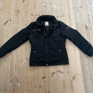 Svart jacka från J.Lindeberg - Säljer en stilren svart jacka från J.Lindeberg i storlek M. Skick 8.5/10, dragkedjan gnisslar lite vilket är enda defekten. Bra jacka för både höst, vinter och vår då den är fodrad. Mitt pris 2000, nytt pris runt 3000. Passar både till vardags och lite finare tillfällen.