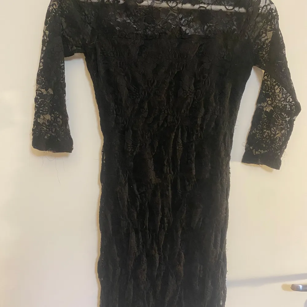 Snygg svart klänning i spets från Lindex i storlek XS. Den har trekvartsärmar och en elegant passform som passar perfekt för festliga tillfällen. Klänningen är i mycket bra skick och ger en stilren look med sin vackra spetsdetalj.. Mekot.