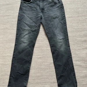 Svarta Levis jeans - Säljer ett par svarta Levis jeans i bra skick. Storlek 38/32!, de har en straight passform och är tillverkade i slitstarkt denim. Perfekta för både vardag och fest!