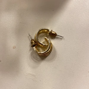 Guldiga örhängen i spiralform - Säljer ett par snygga guldiga örhängen i spiralform. De har en cool, vriden design som ger en unik touch till vilken outfit som helst. Perfekta för både vardag och fest! 🌀✨