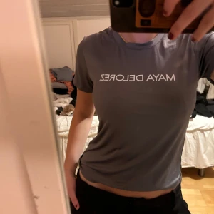 Maya Delorez tröja - Säljer en grå tränings t-shirt från Maya Delorez i mycket bra skick. Den har en normal passform och är kortärmad med vit text på framsidan. Ordinarie pris 350kr