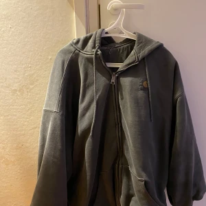 Grå Carhartt vintage jacka. - Säljer en grå jacka från Carhartt i bra skick. Den har en dragkedja framtill och en praktisk huva. Perfekt för höst och vinter, och passar till både vardag och chill. I storleken M. Hör av dig vid intresse!