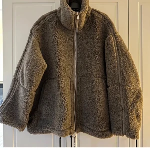 Brun teddyjacka med dragkedja - Säljer denna super populära slutsålda Teddy jackan från hm! Mysig brun teddyjacka i oversized modell med dragkedja framtill. Perfekt för kyliga höst- och vinterdagar. Jackan har långa ärmar och en hög krage för extra värme. Nyskick!! 