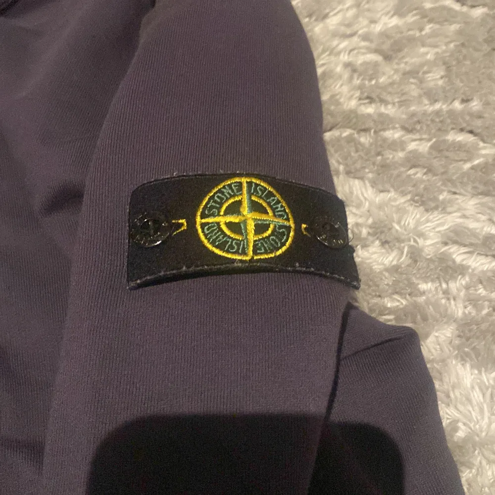 Säljer en snygg mörkblå tröja från Stone Island. Den har en klassisk design med långärmad stil och det ikoniska märket på ärmen. Perfekt för både vardag och lite mer avslappnade tillfällen. Tröjan är i bra skick och redo för en ny ägare! Inga skador! . Tröjor & Koftor.