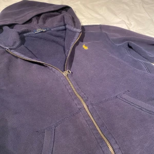 Polo ralph lauren zip - Säljer denna ralph lauren zip hoodie i storlek S. Skicket är rätt så dåligt men det funkar. Den ända defekten sitter vid armen som ni kan se på sissta bilden. Den är även missfärgad tyvär, Därav priset. Men den funkar fortfarande att ha på sig antingen under en väst eller något liknande. Defekten på armen går även att fixa hos en skräddare såklart. Har du några frågot eller vill du ha fler bilder är det bara att höra av sig!!😁😁😁