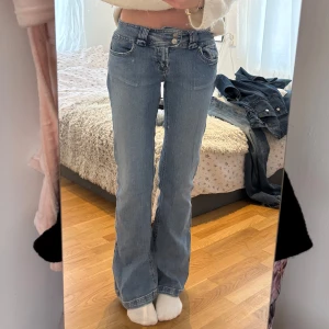 Blå bootcut jeans med hjärtdetalj - Säljer ett par snygga blå bootcut jeans i bra skick. De är lågmidjade och har en söt hjärtdetalj på bakfickorna. Perfekta för både vardag och fest! 💙jag är 173cm lång 🥰 finns en liten fläck längst ner på baksidan av vänstra benet som säkert är lätt att få bort i tvätten 
