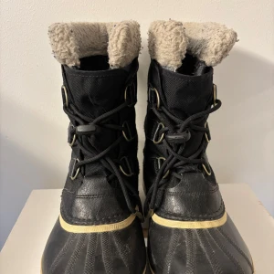Svarta vinterstövlar från Sorel - Säljer ett par svarta Sorel vinterstövlar i mycket bra skick. De är vattentäta och har en mysig pälsfodring som håller fötterna varma. Perfekta för kalla vinterdagar! Stövlarna har snörning framtill och en robust sula för bra grepp. Billiga och varma!!