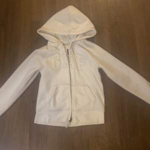 Säljer en superfin vit hoodie från GapKids i storlek 10-11 år. Den har en dragkedja framtill och en mysig huva. GAP-loggan på bröstet är glittrig och ger en extra touch. Perfekt för höst och vår! Den är väldigt mysig och nästan lite foder inuti.