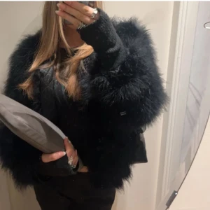 Svart pälsjacka - Säljer en supercool svart pälsjacka i syntetmaterial. Den är perfekt för höst och vinter och har en normal passform. Jackan är långärmad och ger en lyxig känsla till vilken outfit som helst. Perfekt för både vardag och fest!