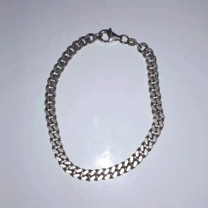 Äkta! Silver armband - Ny pris 1500kr. Snyggt och stilrent silverfärgat armband med klassisk kedjedesign. Perfekt för både vardag och fest. Armbandet har en säker låsning och är i mycket bra skick. Passar perfekt som en tidlös accessoar i din smyckessamling.