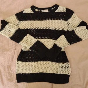 Svart och vit randig tröja från H&M - Säljer en cool svart och vit randig tröja från H&M. Den är stickad med ett luftigt mönster och har långa ärmar. Perfekt för en avslappnad stil under hösten eller våren. Passar bra till jeans eller kjol!