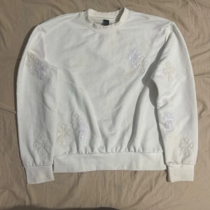 Vit sweatshirt med broderade Y2K Chrome Hearts kor - Säljer en stilren vit sweatshirt från CH med broderade korsdetaljer. Tröjan har en klassisk passform och är perfekt för både vardag och fest. Den är i mycket bra skick och gjord av mjukt material för extra komfort. 